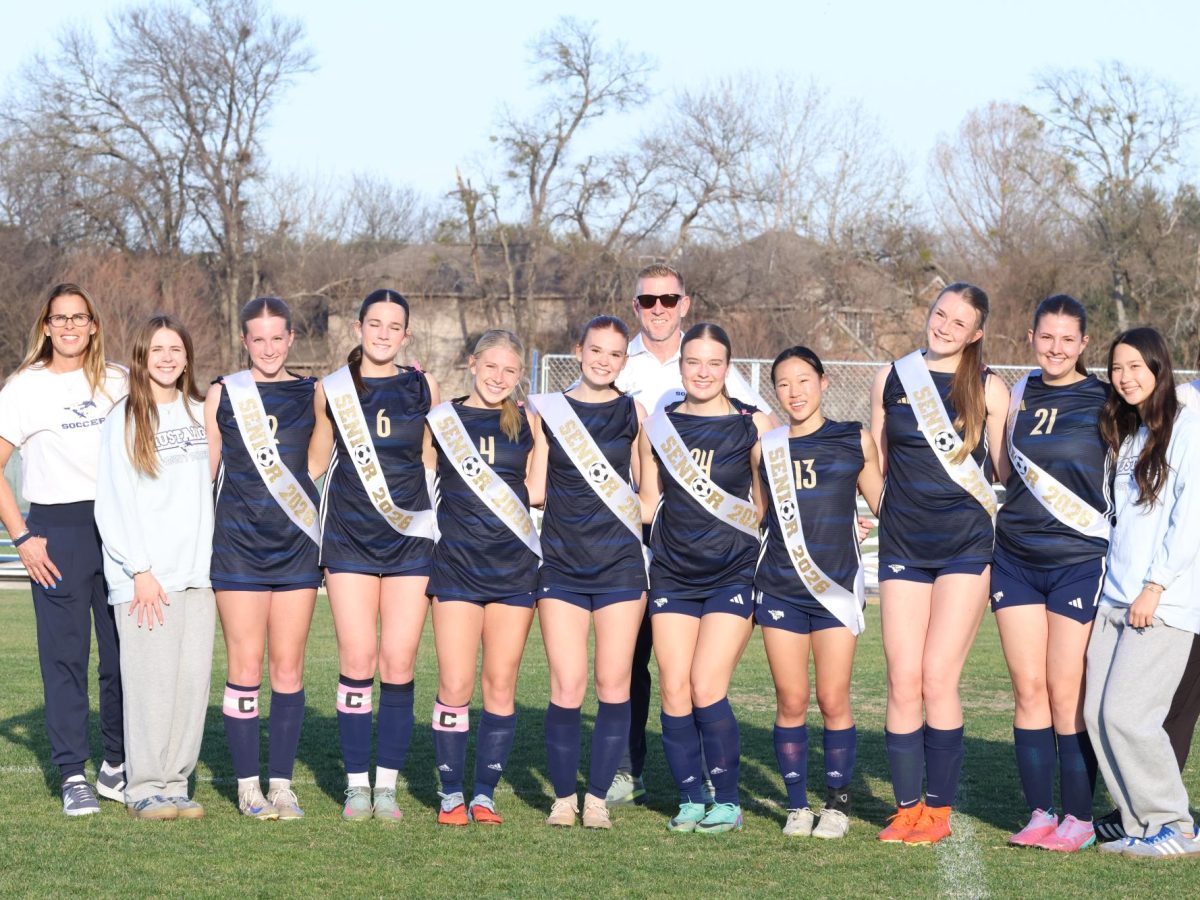 Seniors stand with their coaches for a picture.