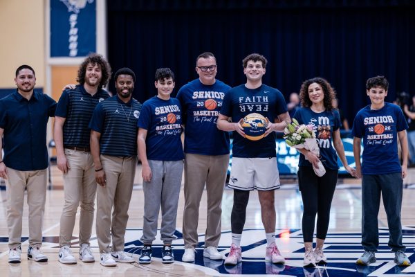 Senior, Daniel Seeley, poses for a picture with his family and the coaches.