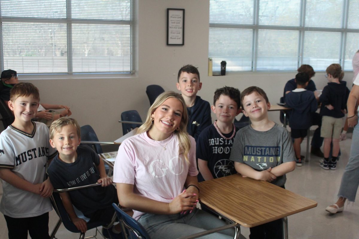 Sophomore, Bella Goodwin poses with second graders. 