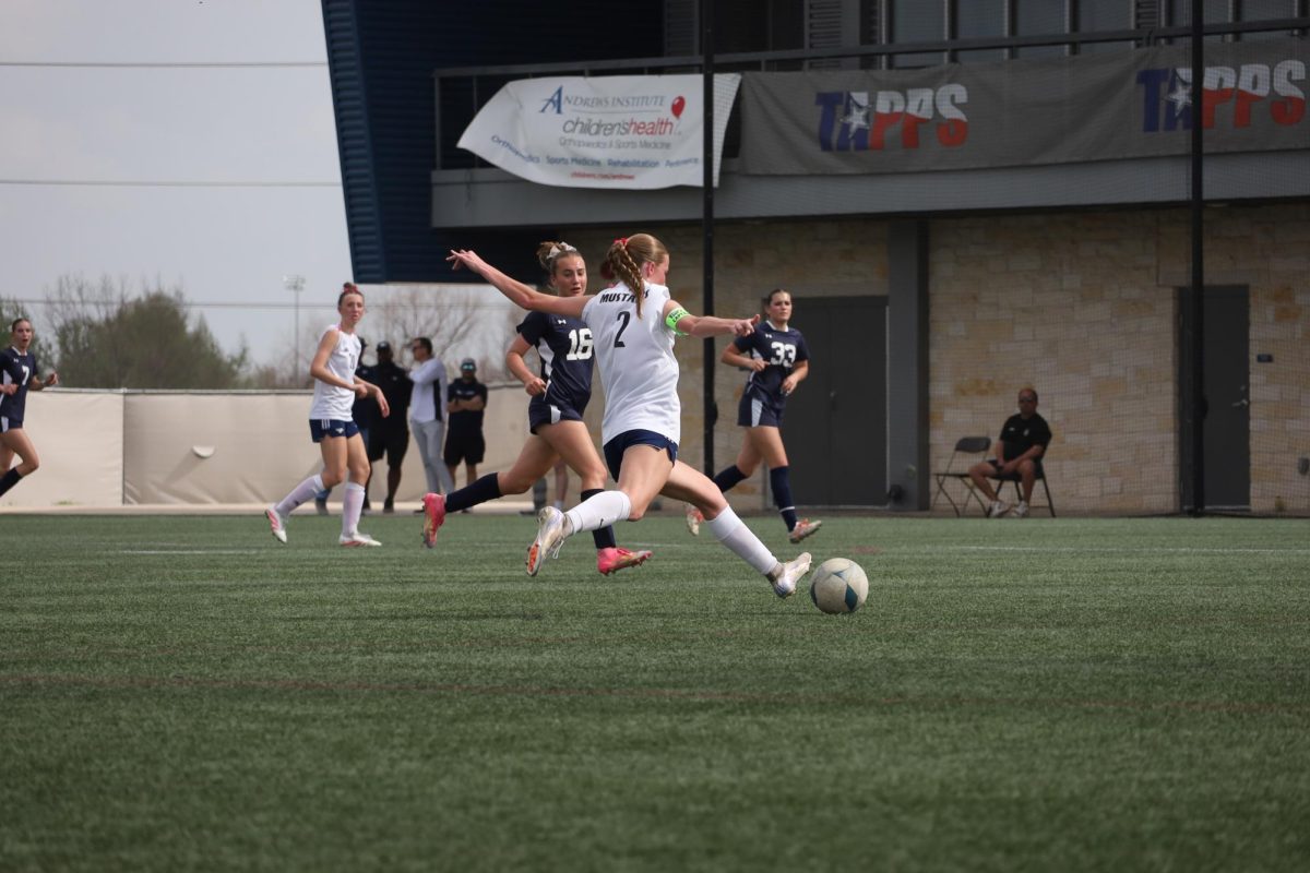 Senior, Hannah Doshier, kicks ball in her state game