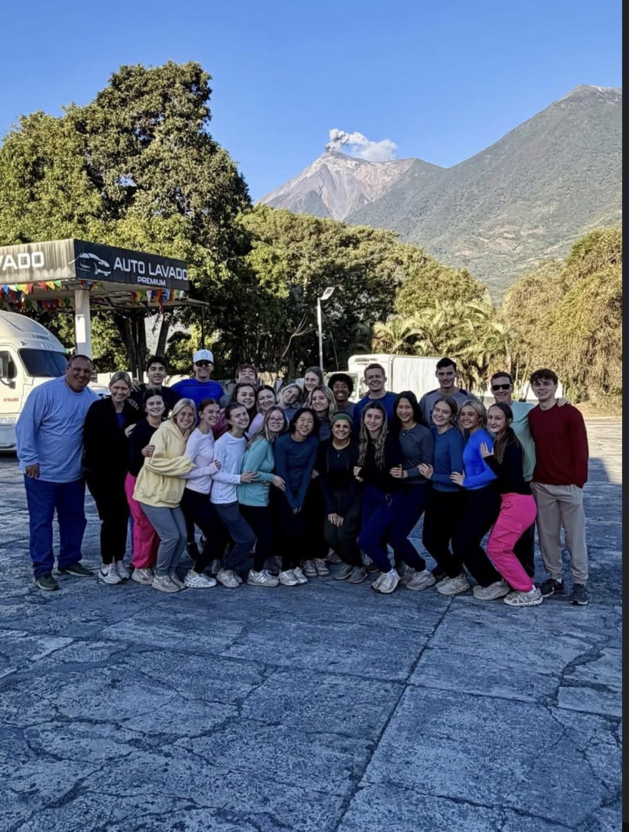 The Guatemala mission team takes a photo in front of a volcano