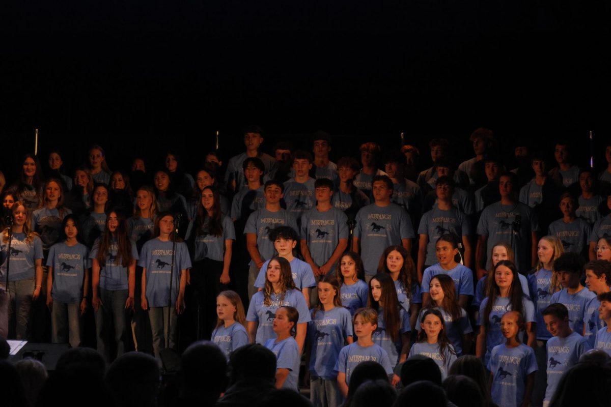 The choir sings "Love Me Do."