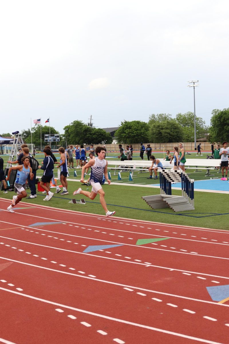 Junior Alex Villarreal sprints around the curve of the track. 