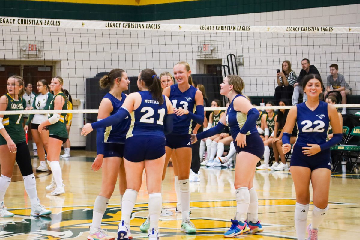 Varisty volleyball team cheers after winning the point.